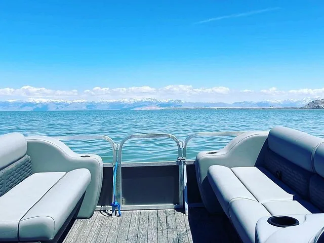 View from the back of a boat on Great Salt Lake towards mountains.