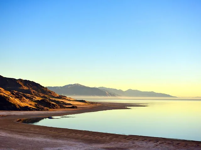 Peaceful sunset view along the shoreline of Great Salt Lake with mountains.